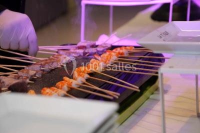 Plateau de sushis variés avec saumon, riz, légumes et feuilles d'endive, présenté sur un support transparent.