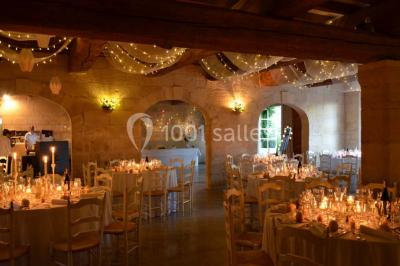 Chambre avec lit ancien en bois sculpté, murs rouges, tables de chevet assorties et miroir ovale.