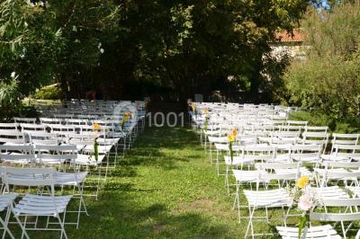 Chambre avec lit ancien en bois sculpté, murs rouges, tables de chevet assorties et miroir ovale.