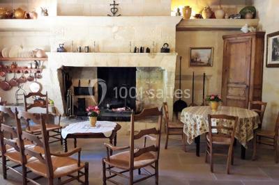 Chambre avec lit ancien en bois sculpté, murs rouges, tables de chevet assorties et miroir ovale.