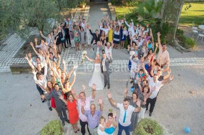 Chambre avec lit ancien en bois sculpté, murs rouges, tables de chevet assorties et miroir ovale.
