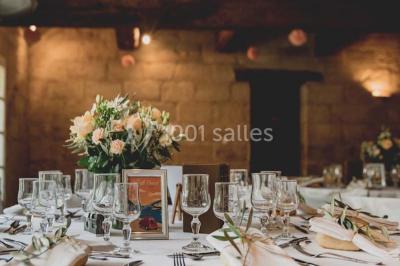 Chambre avec lit ancien en bois sculpté, murs rouges, tables de chevet assorties et miroir ovale.