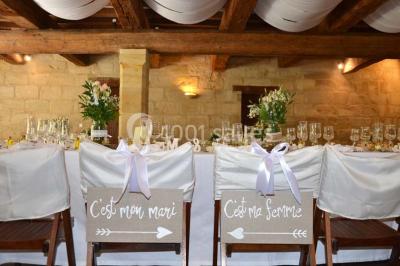 Chambre avec lit ancien en bois sculpté, murs rouges, tables de chevet assorties et miroir ovale.