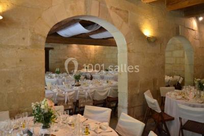 Chambre avec lit ancien en bois sculpté, murs rouges, tables de chevet assorties et miroir ovale.
