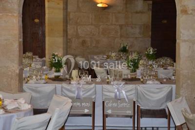 Chambre avec lit ancien en bois sculpté, murs rouges, tables de chevet assorties et miroir ovale.