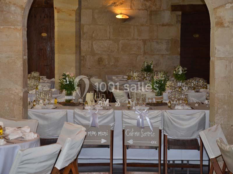 Salle de réception décorée pour un mariage, avec tables dressées, chaises ornées et panneaux indiquant ’mon mari’ et ’ma…