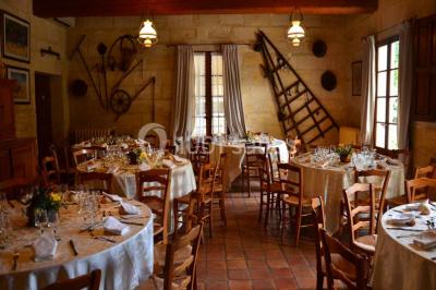 Chambre avec lit ancien en bois sculpté, murs rouges, tables de chevet assorties et miroir ovale.