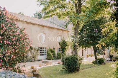 Chambre avec lit ancien en bois sculpté, murs rouges, tables de chevet assorties et miroir ovale.