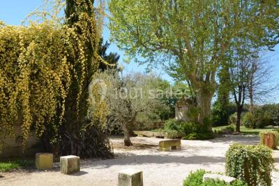 Chambre avec lit ancien en bois sculpté, murs rouges, tables de chevet assorties et miroir ovale.