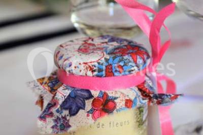 Chambre avec lit ancien en bois sculpté, murs rouges, tables de chevet assorties et miroir ovale.