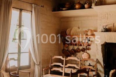 Chambre avec lit ancien en bois sculpté, murs rouges, tables de chevet assorties et miroir ovale.