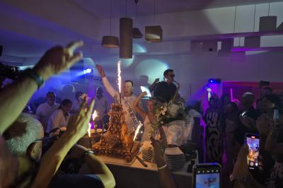 Table décorée pour une fête avec des donuts glacés bleus, des cubes décoratifs et des desserts variés sur des supports en…