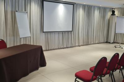 Salle aménagée avec des rangées de chaises rouges alignées, prête pour un événement ou une réunion.