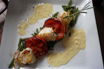 Corbeille garnie de fruits variés et fleurs décoratives, posée sur une table dans un environnement faiblement éclairé.