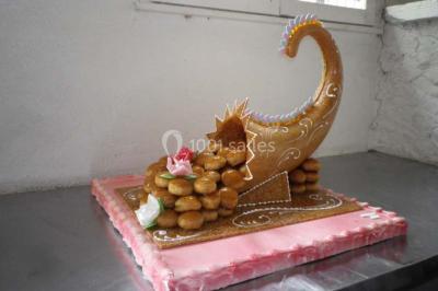 Corbeille garnie de fruits variés et fleurs décoratives, posée sur une table dans un environnement faiblement éclairé.