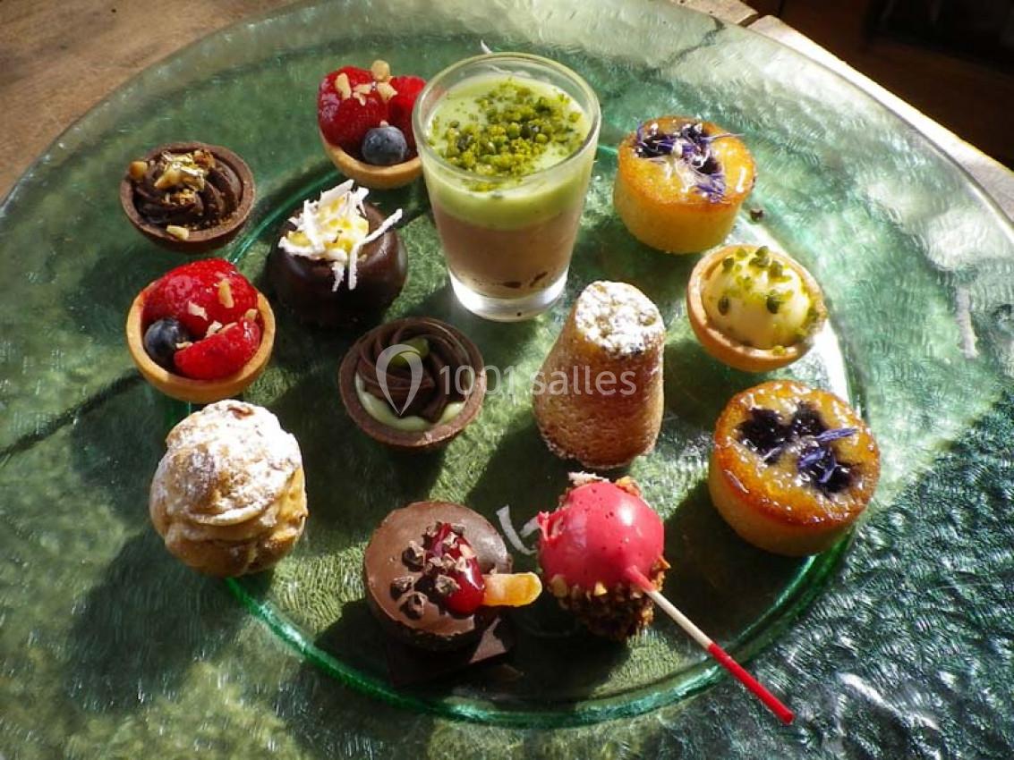 Assortiment de petits desserts variés disposés sur une assiette en verre transparent.