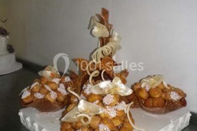 Corbeille garnie de fruits variés et fleurs décoratives, posée sur une table dans un environnement faiblement éclairé.