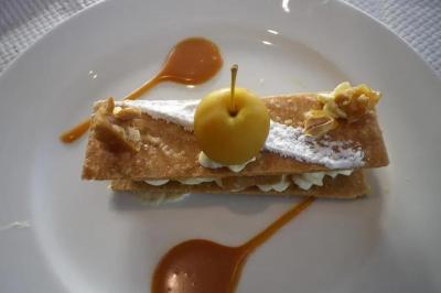 Corbeille garnie de fruits variés et fleurs décoratives, posée sur une table dans un environnement faiblement éclairé.
