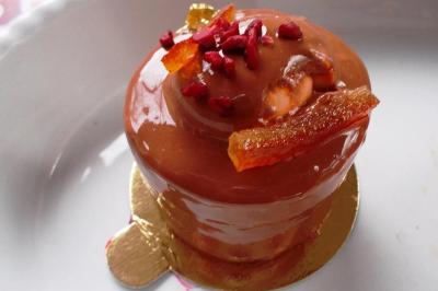 Corbeille garnie de fruits variés et fleurs décoratives, posée sur une table dans un environnement faiblement éclairé.