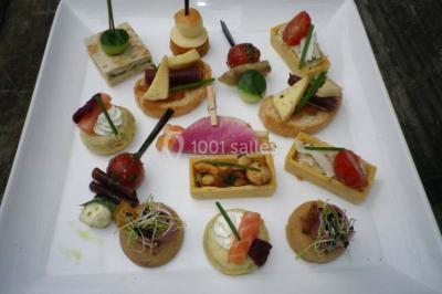 Corbeille garnie de fruits variés et fleurs décoratives, posée sur une table dans un environnement faiblement éclairé.