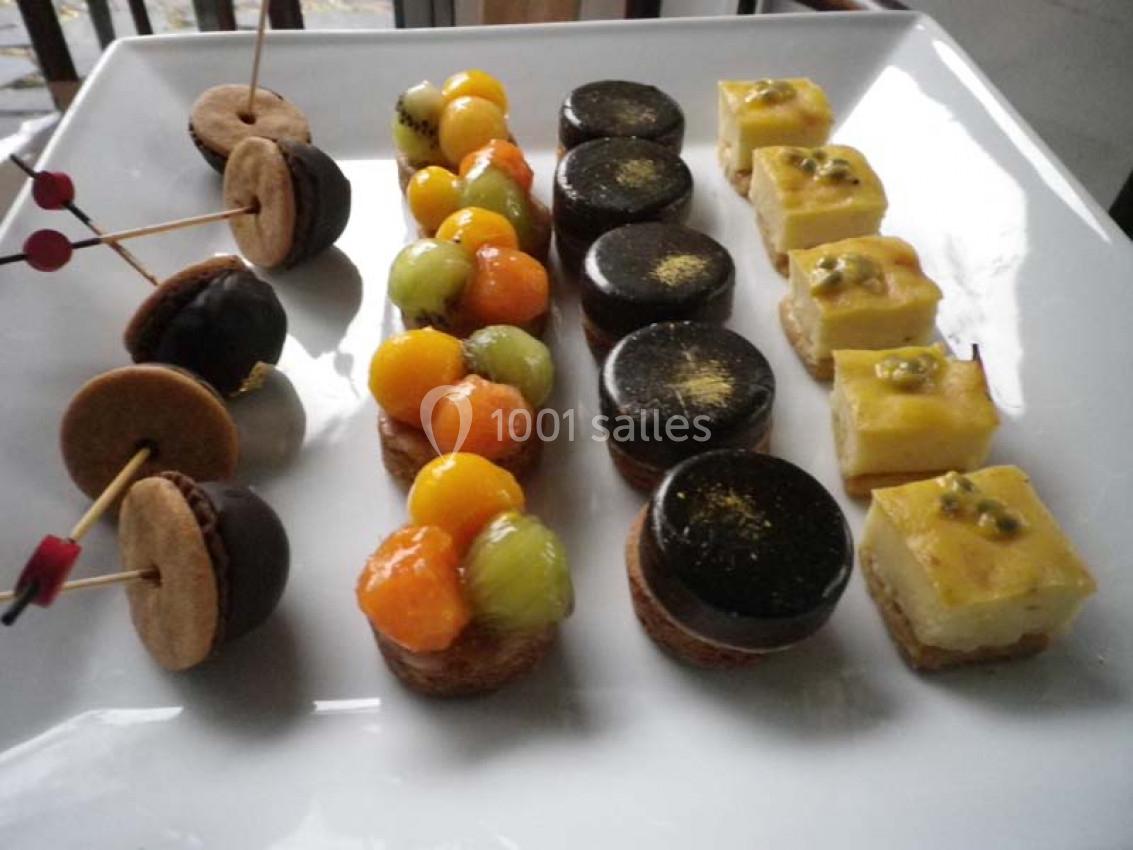 Assortiment de mignardises sur un plateau, comprenant tartelettes aux fruits, gâteaux au chocolat et bouchées au fruit de la…
