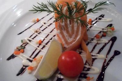 Corbeille garnie de fruits variés et fleurs décoratives, posée sur une table dans un environnement faiblement éclairé.
