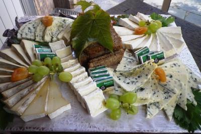 Corbeille garnie de fruits variés et fleurs décoratives, posée sur une table dans un environnement faiblement éclairé.