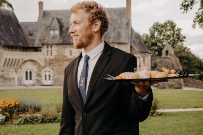 Plateau de bouchées apéritives variées présentées sur des supports en bois, avec une pancarte ’Cocktail’.