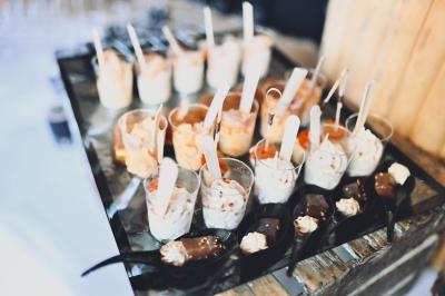 Plateau de bouchées apéritives variées présentées sur des supports en bois, avec une pancarte ’Cocktail’.