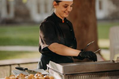 Viande en morceaux grillant sur une plaque chauffante, retournée à l'aide d'une spatule métallique.