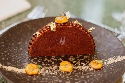 Assiette gastronomique avec filet de viande, purée de carottes, garniture de légumes et sauce décorative.