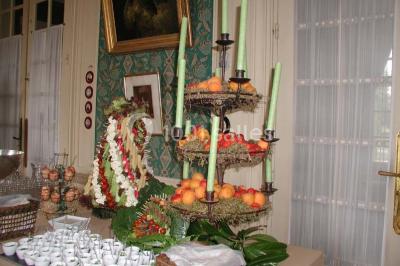 Façade d'un château en briques rouges et blanches avec un toit en ardoise, entouré d'un jardin bien entretenu.