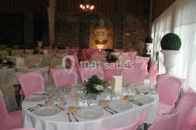 Façade d'un château en briques rouges et blanches avec un toit en ardoise, entouré d'un jardin bien entretenu.