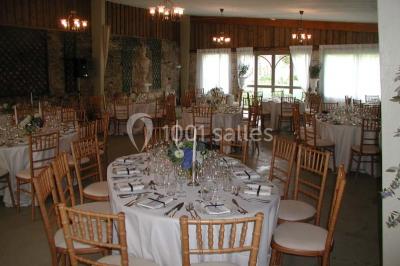 Façade d'un château en briques rouges et blanches avec un toit en ardoise, entouré d'un jardin bien entretenu.