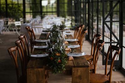 Miniature Traiteur Aix-en-Provence (Bouches-du-Rhône) - Carré Gourmand #11 Une mariée en robe blanche tient un bouquet dans une salle décorée pour un mariage, avec un homme en costume bleu derrière…