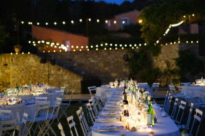 Miniature Traiteur Aix-en-Provence (Bouches-du-Rhône) - Carré Gourmand #12 Une mariée en robe blanche tient un bouquet dans une salle décorée pour un mariage, avec un homme en costume bleu derrière…