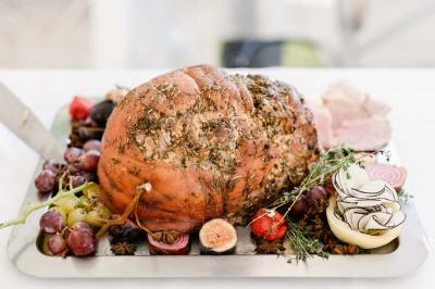 Miniature Traiteur Aix-en-Provence (Bouches-du-Rhône) - Carré Gourmand #3 Une mariée en robe blanche tient un bouquet dans une salle décorée pour un mariage, avec un homme en costume bleu derrière…