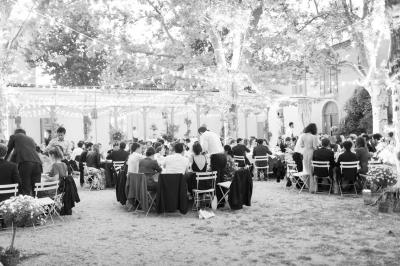 Miniature Traiteur Aix-en-Provence (Bouches-du-Rhône) - Carré Gourmand #10 Une mariée en robe blanche tient un bouquet dans une salle décorée pour un mariage, avec un homme en costume bleu derrière…