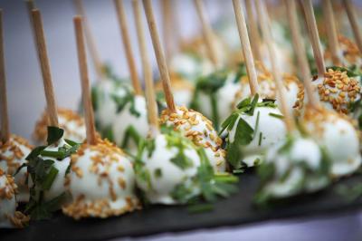 Miniature Traiteur Aix-en-Provence (Bouches-du-Rhône) - Carré Gourmand #6 Une mariée en robe blanche tient un bouquet dans une salle décorée pour un mariage, avec un homme en costume bleu derrière…