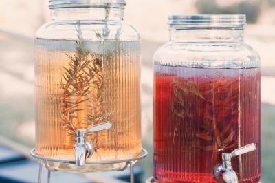 Miniature Traiteur Aix-en-Provence (Bouches-du-Rhône) - Carré Gourmand #24 Une mariée en robe blanche tient un bouquet dans une salle décorée pour un mariage, avec un homme en costume bleu derrière…