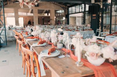 Miniature Traiteur Aix-en-Provence (Bouches-du-Rhône) - Carré Gourmand #28 Une mariée en robe blanche tient un bouquet dans une salle décorée pour un mariage, avec un homme en costume bleu derrière…