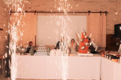 Miniature Traiteur Aix-en-Provence (Bouches-du-Rhône) - Carré Gourmand #29 Une mariée en robe blanche tient un bouquet dans une salle décorée pour un mariage, avec un homme en costume bleu derrière…