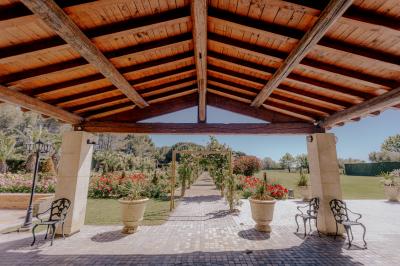 Une mariée souriante brandit un éventail devant un gâteau de mariage décoré, entourée d'invités en extérieur.
