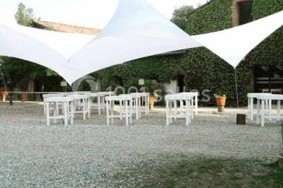 Chemin bordé d'arbres menant à un kiosque en bois avec un toit en tuiles, entouré de verdure.