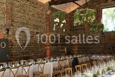 Chemin bordé d'arbres menant à un kiosque en bois avec un toit en tuiles, entouré de verdure.