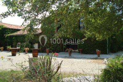 Chemin bordé d'arbres menant à un kiosque en bois avec un toit en tuiles, entouré de verdure.