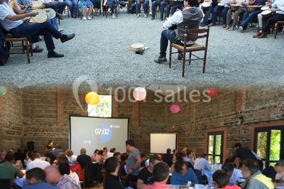 Chemin bordé d'arbres menant à un kiosque en bois avec un toit en tuiles, entouré de verdure.