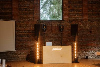 Chemin bordé d'arbres menant à un kiosque en bois avec un toit en tuiles, entouré de verdure.