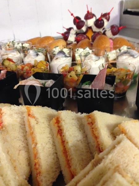Assortiment de sandwichs, verrines et amuse-bouches disposés sur une table.