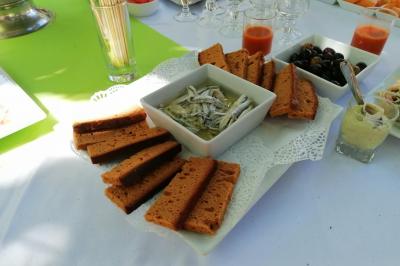 Manoir ancien entouré d'arbres, avec une pelouse en premier plan et un ciel clair en arrière-plan.